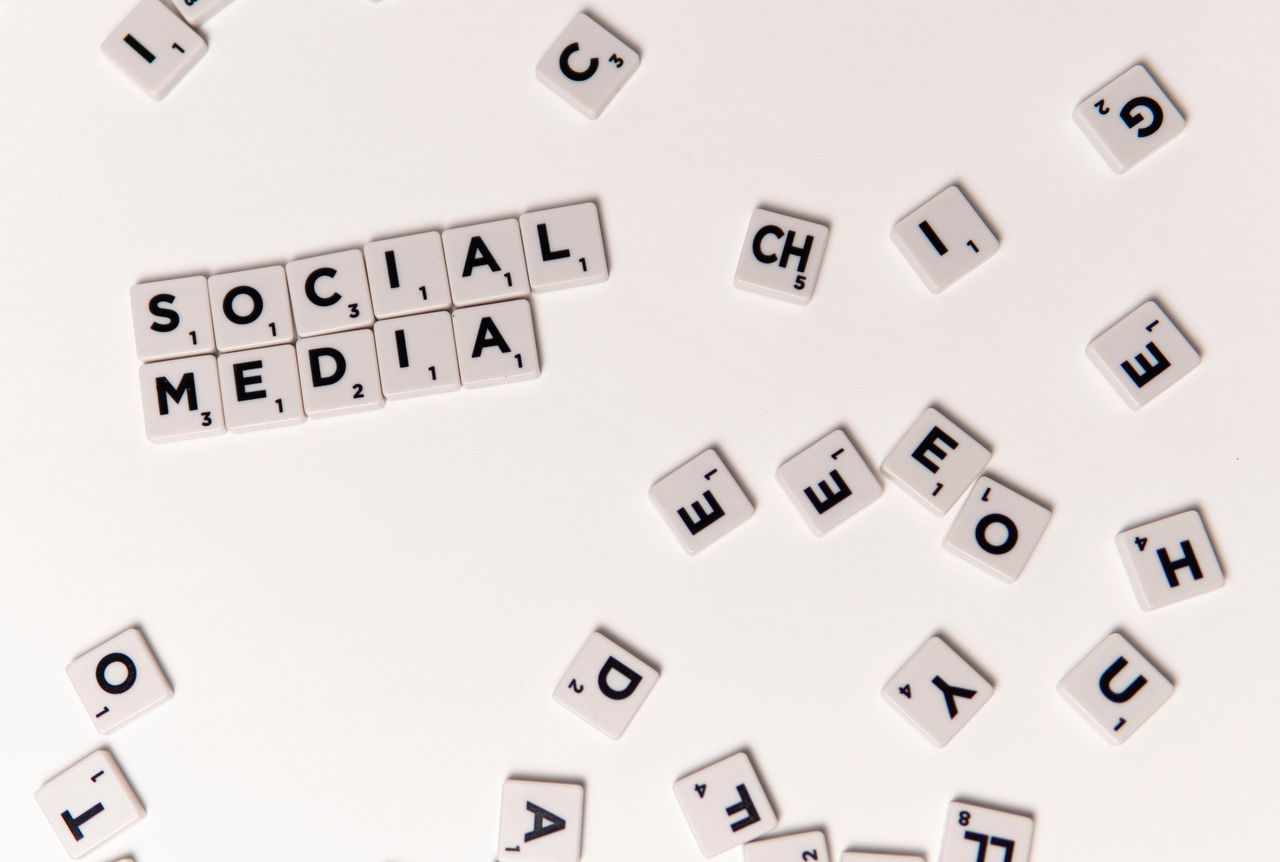 Scrabble tiles spelling Social Media on a white background, symbolizing digital communication.